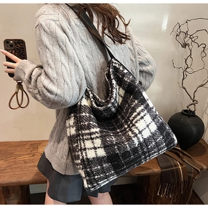 Detail of a large houndstooth pattern tote bag worn on shoulder for autumn style