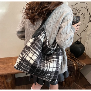 Detailed view of large black and white checkered tote bag with black leather straps