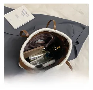 Top view of plush-trimmed tote bag interior showing large capacity for cosmetics and phone