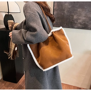 Brown suede tote bag with white faux shearling trim shown on model in a cozy indoor setting