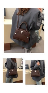 Detail of dark brown lychee pattern leather handbag with silver lock and shoulder strap