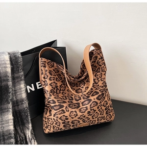 Detailed close-up of leopard print suede tote with premium brown leather handles