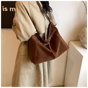 Close-up of large dark coffee suede tote bag with leather strap on a model shoulder