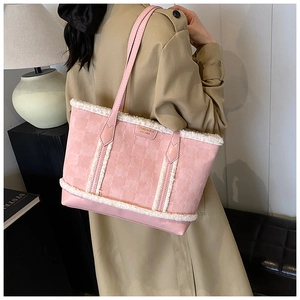 Pink tote bag detail with plush trim and embossed clover pattern on synthetic leather