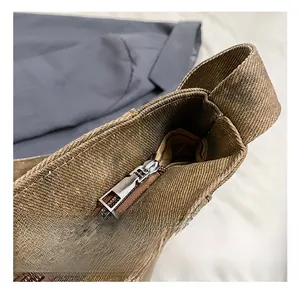 Close-up of premium silver metal zipper on brown canvas tote bag with retro washing texture
