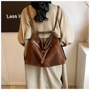Brown suede tote bag shown in a lifestyle shot with a khaki trench coat for commuting