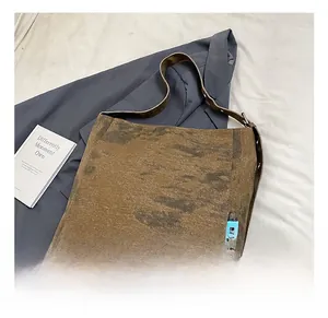 Detail view of coffee brown canvas tote bag with woven labels and vintage wash texture