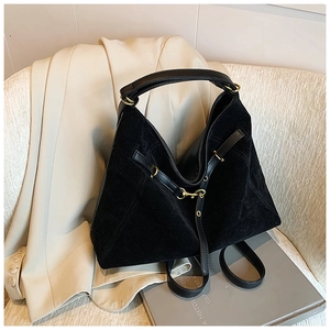 Detail view of black suede hobo bag with gold hardware and leather strap for women