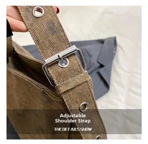 Close-up of adjustable canvas shoulder strap with silver metal buckle and reinforced eyelets
