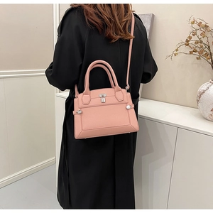Detail of pink lychee leather tote bag featuring silver metal lock and textured finish