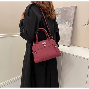 Burgundy leather tote with lychee texture and metal lock shown on a model