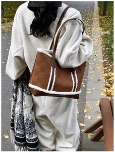 Detail of winter tote bag featuring brown faux leather and white plush shearling trim