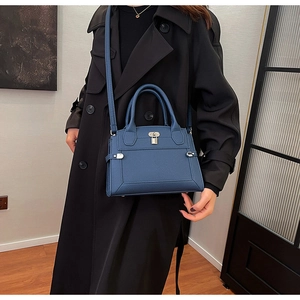 Detail of blue lychee grain leather tote bag with silver lock and adjustable shoulder strap
