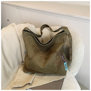 Detail view of large canvas tote bag showing washed denim texture and wide shoulder strap