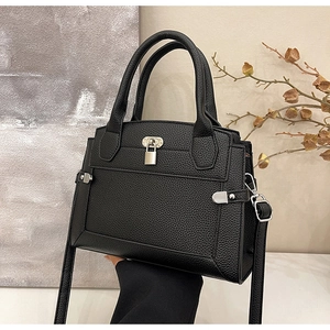 Detailed shot of black lychee leather handbag with silver rotary lock and padlock