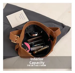 Detail view showing large internal capacity with zipper pocket in a brown leather tote bag