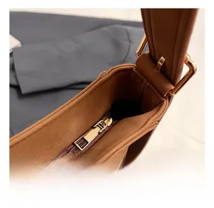 Close-up of golden zipper hardware and matte brown texture on the vintage tote bag