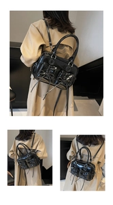 Detail of black patent leather bag with white contrast stitching and bow decoration