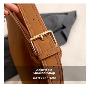 Detail showing the adjustable brown leather strap with a polished gold metal buckle