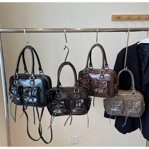 Detail of four glossy faux leather boston bags in black, coffee, brown, and grey colors