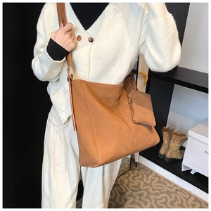 Detail view of large caramel brown tote bag with matching small coin pouch on shoulder strap