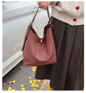 Détail du sac cabas en daim bordeaux avec bandoulière en cuir et boucle dorée en automne