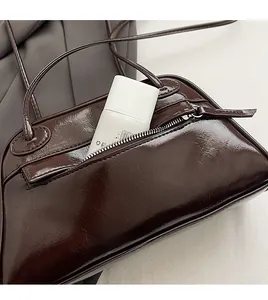 Detail view of the secure anti-theft back pocket on this brown faux leather shoulder bag