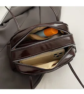 Detail view of large capacity dark brown faux leather shoulder bag with double zippers