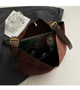 Vue macro de l'intérieur d'un grand sac cabas en daim marron avec bandoulière réglable