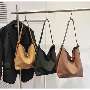 Trois sacs cabas en daim en caramel, noir et café pour un look de bureau élégant