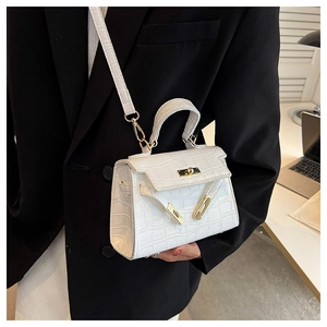 Detailed view of white crocodile pattern texture on Kelly style bag with gold hardware
