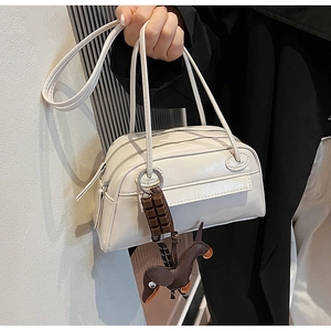 Detail of white PU shoulder bag with dual zipper structure and cute charms