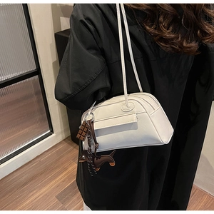 White PU leather Boston shoulder bag detail featuring cute sausage dog bag charm