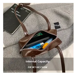 Internal view of glossy brown underarm bag showing space for phone and makeup