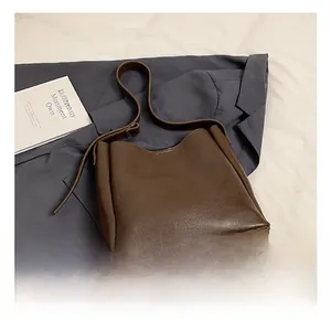 Detail of dark brown leather texture and stitching on the large capacity tote bag