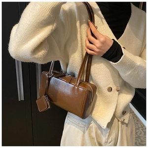 Detail of vintage brown leather tote bag with a matching small square coin purse pendant