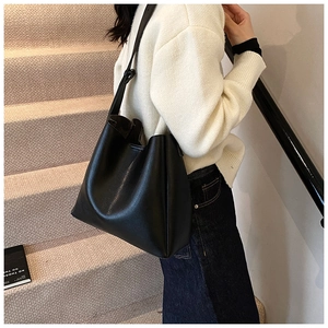 Detail of black large capacity PU leather tote bag with wide strap and soft texture