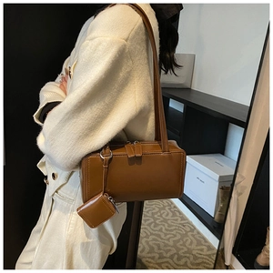 Close-up of a brown rectangle baguette bag with a matching mini zip pouch on the shoulder strap
