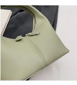 Detail shot of sage green faux leather handbag showing smooth texture and stitching