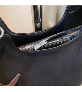 Détail de la fermeture éclair argentée sur un sac à main en daim noir élégant