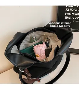Vue intérieure montrant la grande capacité du sac fourre-tout noir et l'espace de rangement