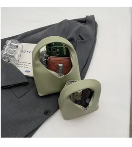 Close-up of matte green handbags showing spacious interior with phone and wallet