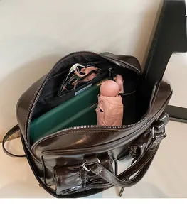 Spacious interior of dark brown leather tote bag showing pockets for umbrella and notebook