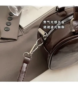 Detailed close-up of shiny silver metal zipper and dark brown patent leather texture