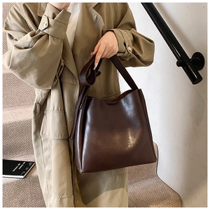 Close-up of a large dark brown leather tote bag with wide strap for daily commute
