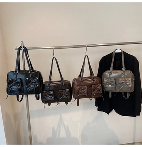Detailed view of glossy vintage leather tote bags in black, brown, caramel, and green colors