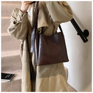 Detail of dark brown vintage leather bucket bag with wide adjustable shoulder strap