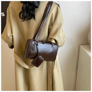Detail of dark brown mirror-finish tote bag with dual straps and small matching pouch