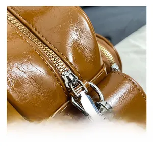 Detail of vintage brown oily leather texture and silver metal zipper on a tote bag