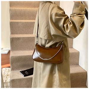 Detail view of dark brown leather crescent bag with silver chain and NO FILTER text
